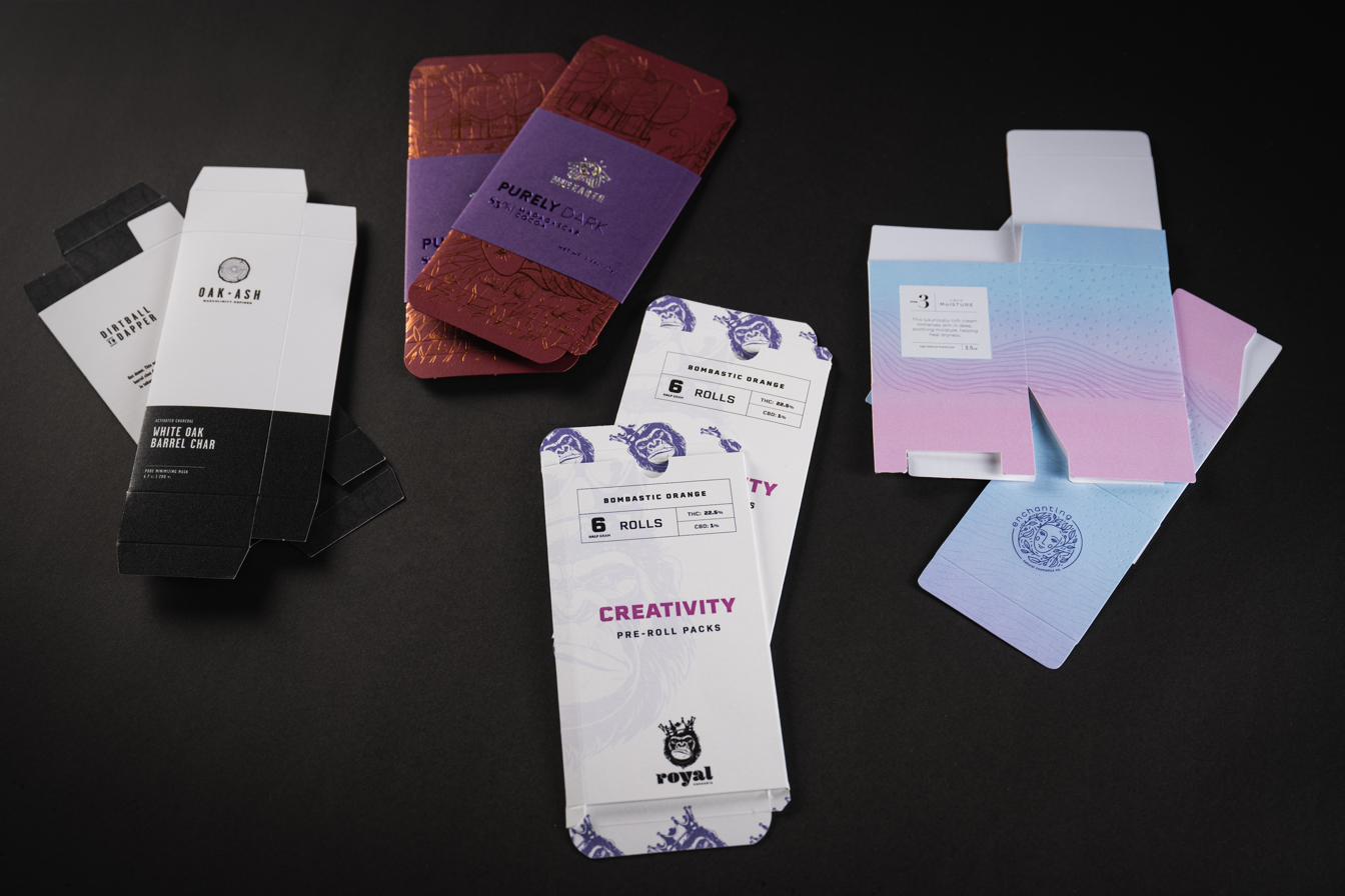 Four folding cartons as flat, printed, die-cut blanks before folding and gluing.