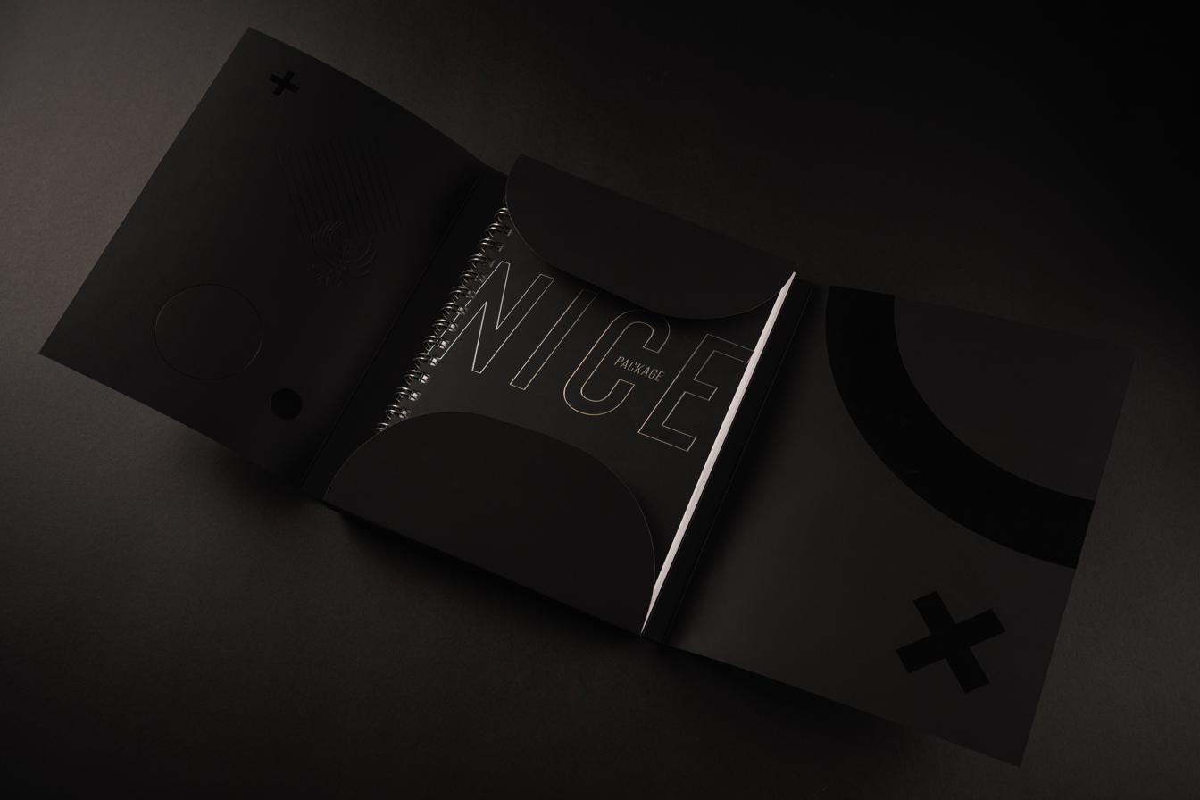 The Nice Package slipcase open, the wire-bound sample book emerging from inside on a dark ground.
